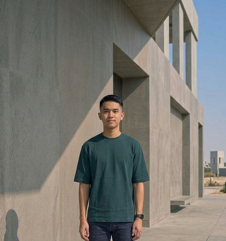  Known Clothing blue oversized t-shirt front view on male model against urban building backdrop